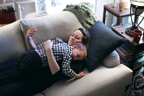 mom-son-hugging-couch-home-with-heating